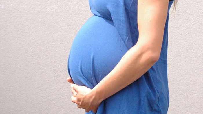 schwangere Frau mit Händen am Bauch