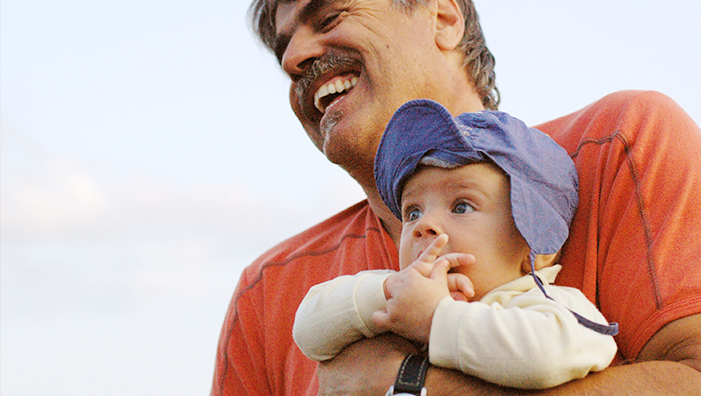 Bild eines Vaters mit seinem Kind am Arm
