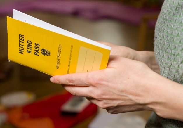 Hände halten einen Mutter-Kind-Pass