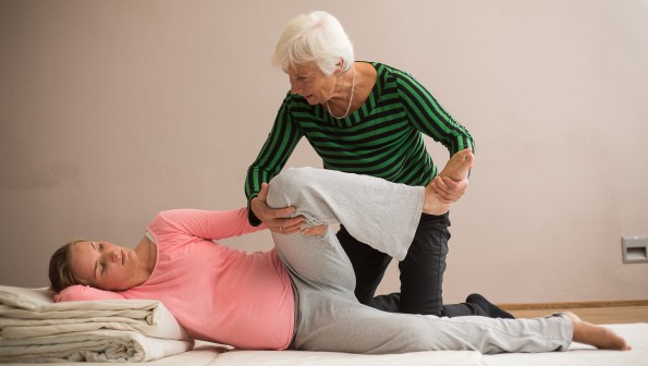 Schwangere und Hebamme üben eine Geburtspositioneburten