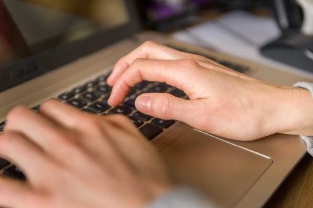 Hände auf Tastatur tippend